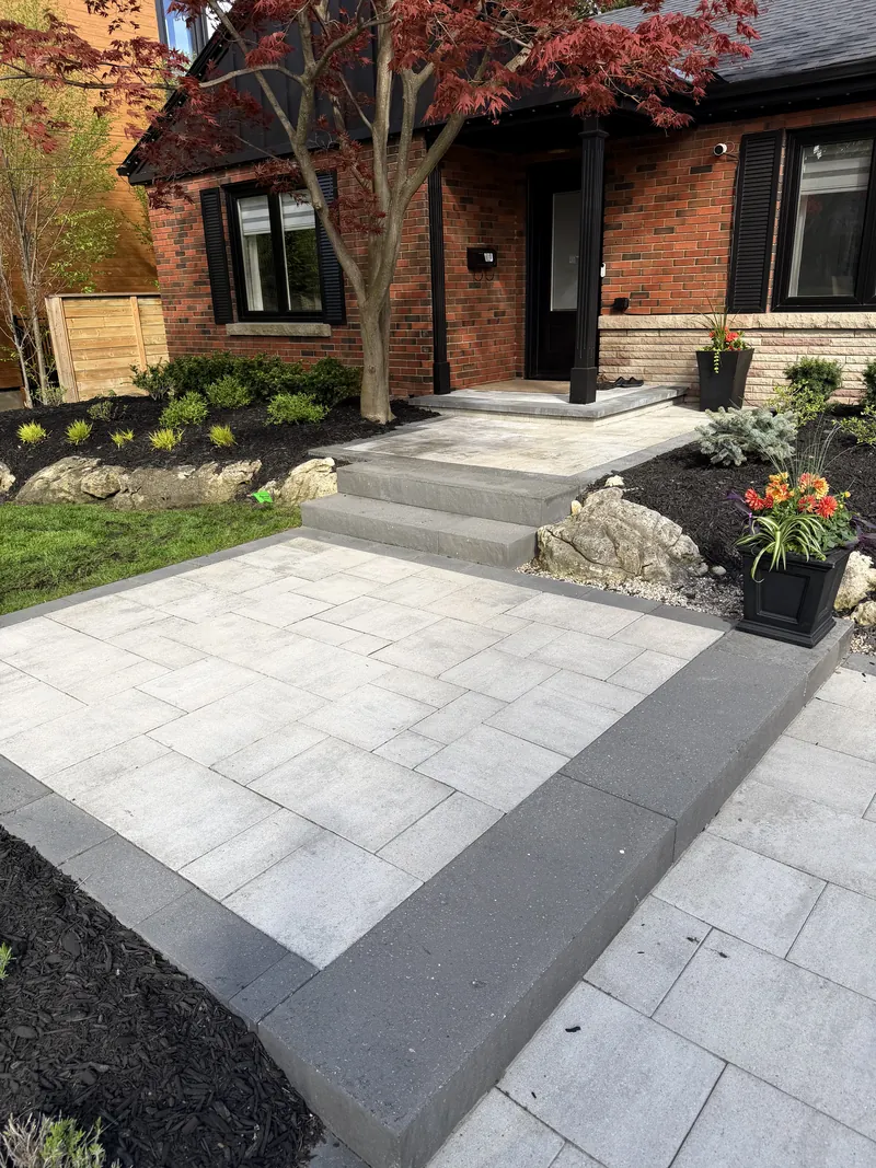 The finished entrance seen from the street, Japanese maple over the boulder-set bed.