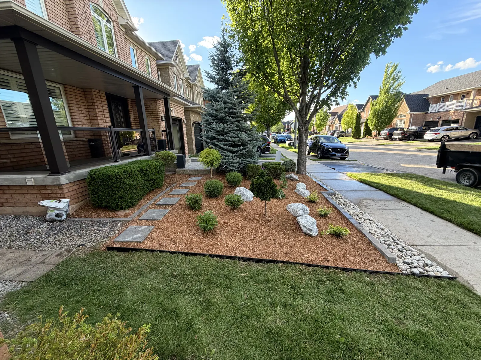 Established front bed with layered planting and a clean mulch edge against the lawn.